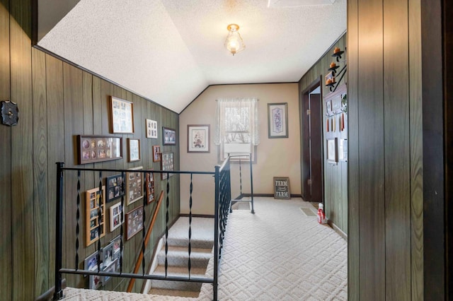 44655 Red Oak Rd, Staples, MN 56479 - hallway featuring carpet floors, baseboards, a textured ceiling, vaulted ceiling, and wood walls