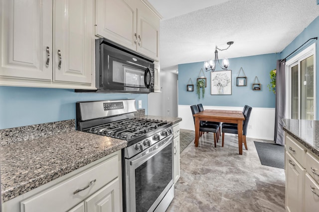5019 Washington St NE, Columbia Heights, MN 55421 - kitchen featuring stainless steel range with gas stovetop, black microwave, a chandelier, white cabinetry, and dark stone counters