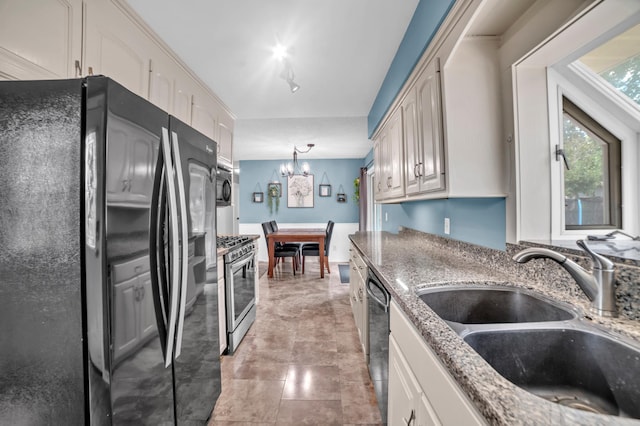 5019 Washington St NE, Columbia Heights, MN 55421 - kitchen featuring black appliances, a chandelier, light stone counters, pendant lighting, and white cabinetry