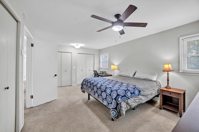 5019 Washington St NE, Columbia Heights, MN 55421 - bedroom featuring two closets, multiple windows, carpet flooring, and a ceiling fan