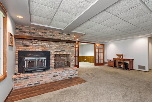 19260 81st Pl N, Maple Grove, MN 55311 - carpeted living area with a wood stove, recessed lighting, a wainscoted wall, baseboards, and a paneled ceiling