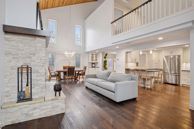3715 Huntingdon Dr, Minnetonka, MN 55305 - living area featuring high vaulted ceiling, dark wood-type flooring, and a stone fireplace