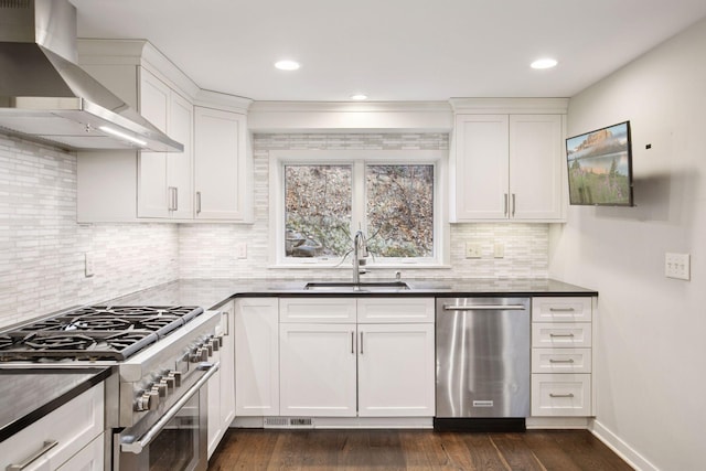 3715 Huntingdon Dr, Minnetonka, MN 55305 - kitchen with wall chimney range hood, appliances with stainless steel finishes, a sink, dark wood-style floors, and tasteful backsplash