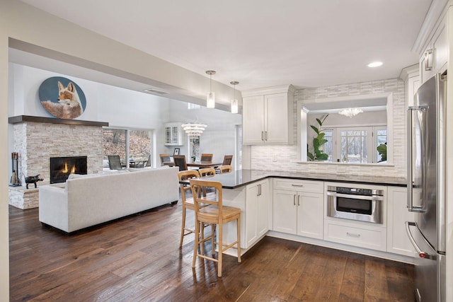 3715 Huntingdon Dr, Minnetonka, MN 55305 - kitchen featuring stainless steel appliances, a chandelier, dark countertops, dark wood-style floors, and white cabinets