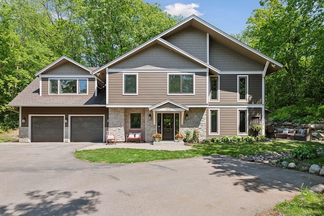 3715 Huntingdon Dr, Minnetonka, MN 55305 - view of front of property with asphalt driveway, stone siding, an attached garage, and an outdoor living space