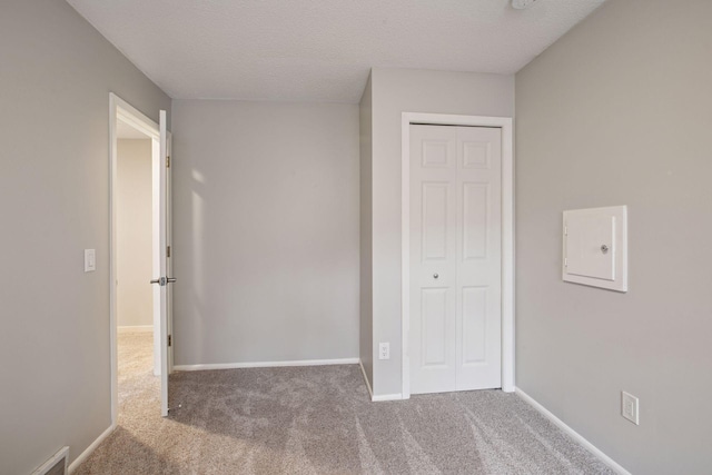 3715 Huntingdon Dr, Minnetonka, MN 55305 - unfurnished bedroom featuring a closet, carpet floors, baseboards, and a textured ceiling