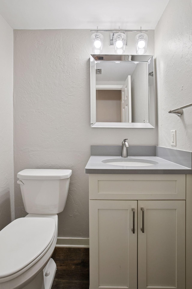 3715 Huntingdon Dr, Minnetonka, MN 55305 - bathroom with wood finished floors, vanity, toilet, baseboards, and a textured wall