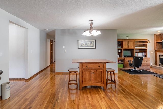 32 7th St, Buffalo City, WI 54622 - dining area with light wood-style flooring, an office area, a textured ceiling, and a chandelier