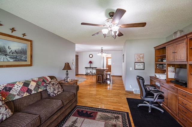 32 7th St, Buffalo City, WI 54622 - office area with light wood-type flooring, a ceiling fan, a chandelier, and a textured ceiling