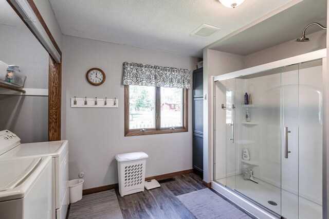 32 7th St, Buffalo City, WI 54622 - full bath with washer and dryer, wood finished floors, a stall shower, and a textured ceiling