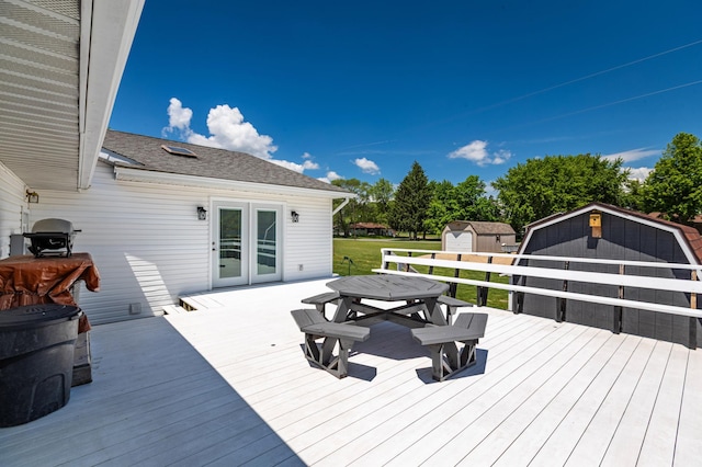 32 7th St, Buffalo City, WI 54622 - wooden deck featuring a storage unit, outdoor dining space, french doors, and a lawn