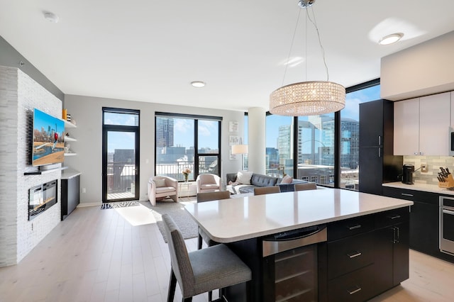 740 Portland Ave Unit 907, Minneapolis, MN 55415 - kitchen with beverage cooler, dark cabinetry, a large fireplace, and light countertops