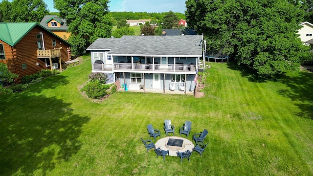 27668 Crappie Trl, Sverdrup Twp, MN 56586 - back of house featuring a fire pit, a patio area, a trampoline, a yard, and a wooden deck