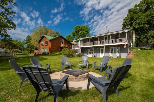27668 Crappie Trl, Sverdrup Twp, MN 56586 - back of house featuring a fire pit, a yard, a wooden deck, a patio area, and log siding
