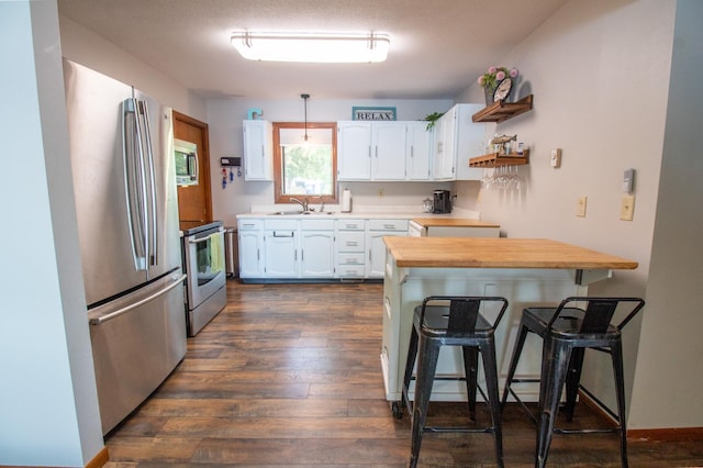 27668 Crappie Trl, Sverdrup Twp, MN 56586 - kitchen featuring appliances with stainless steel finishes, a sink, white cabinets, butcher block counters, and a breakfast bar area