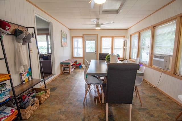 27668 Crappie Trl, Sverdrup Twp, MN 56586 - dining area featuring wooden walls, a ceiling fan, cooling unit, stone finish flooring, and crown molding