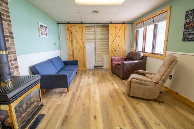 27668 Crappie Trl, Sverdrup Twp, MN 56586 - living room with a barn door, a paneled ceiling, wood finished floors, and wainscoting