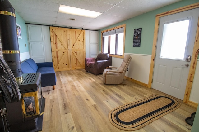 27668 Crappie Trl, Sverdrup Twp, MN 56586 - living area with light wood-type flooring, a drop ceiling, baseboards, and a barn door