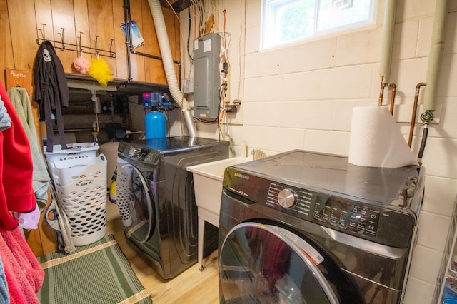 27668 Crappie Trl, Sverdrup Twp, MN 56586 - laundry area featuring electric panel, independent washer and dryer, light wood finished floors, and concrete block wall