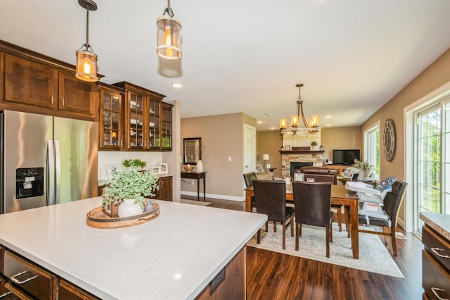 13284 288th Ave NW, Zimmerman, MN 55398 - kitchen featuring stainless steel fridge, dark wood-type flooring, a fireplace, hanging light fixtures, and recessed lighting