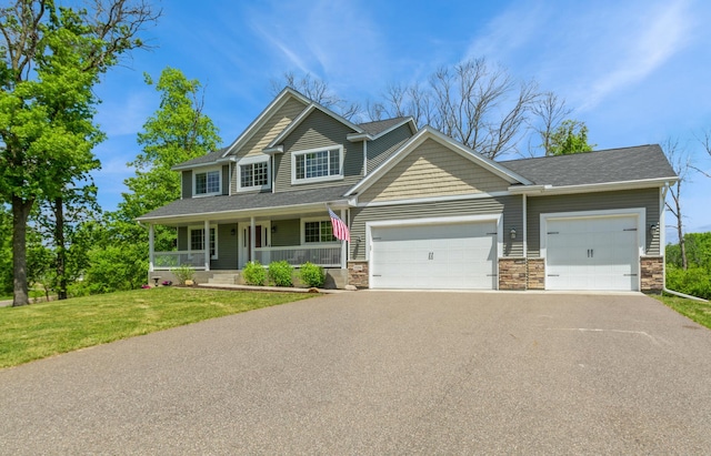 13284 288th Ave NW, Zimmerman, MN 55398 - view of front of home featuring driveway, a garage, stone siding, and covered porch