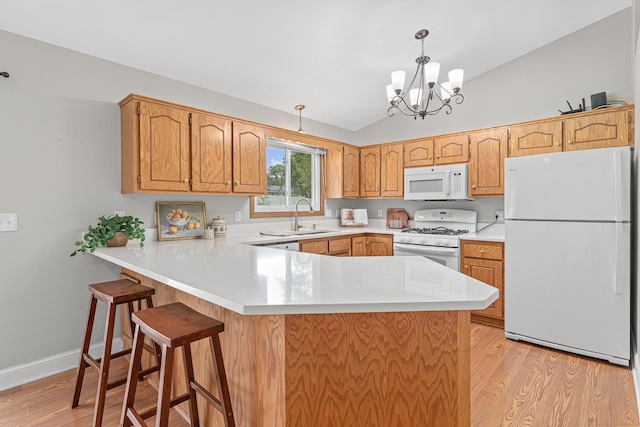 1112 Dakota St S, Shakopee, MN 55379 - kitchen featuring white appliances, a peninsula, vaulted ceiling, light wood-style flooring, and light countertops