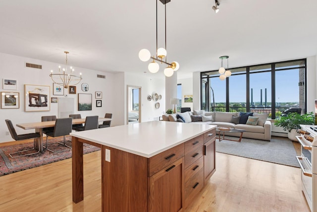 215 10th Ave S Unit 606, Minneapolis, MN 55415 - kitchen featuring a chandelier, light wood-style floors, light countertops, brown cabinets, and a kitchen island