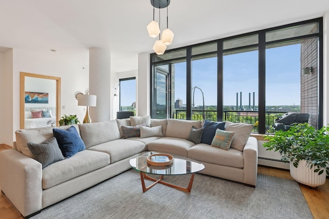 215 10th Ave S Unit 606, Minneapolis, MN 55415 - living room featuring wood finished floors, a baseboard heating unit, plenty of natural light, and a wall of windows