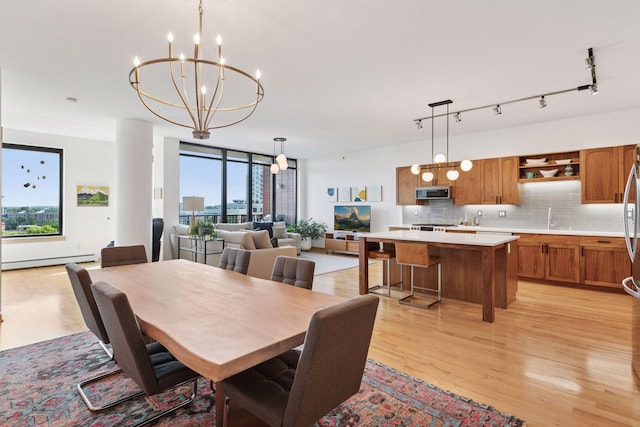 215 10th Ave S Unit 606, Minneapolis, MN 55415 - dining room with light wood-style floors, a chandelier, baseboard heating, and expansive windows