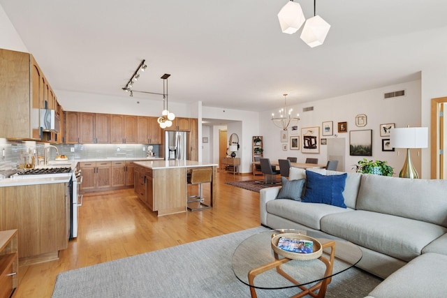 215 10th Ave S Unit 606, Minneapolis, MN 55415 - living area featuring light wood-type flooring, a chandelier, and rail lighting
