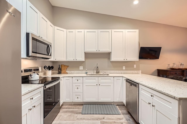 4271 Boulder Ridge Pt, Eagan, MN 55122 - kitchen with appliances with stainless steel finishes, a sink, lofted ceiling, a peninsula, and light wood finished floors