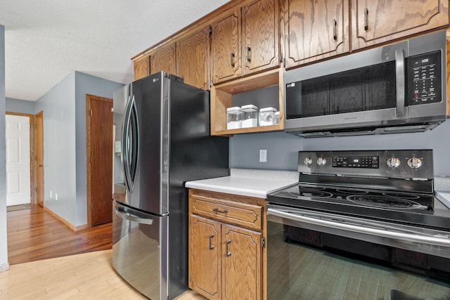 16724 Kenyon Cir NE, Ham Lake, MN 55304 - kitchen featuring appliances with stainless steel finishes, light wood finished floors, light countertops, and brown cabinets