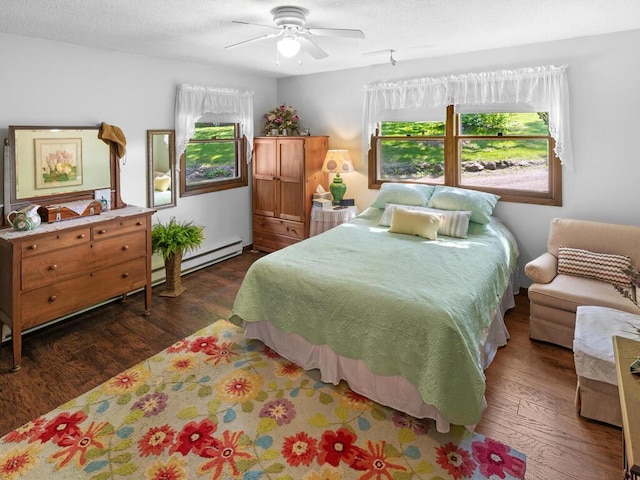24810 96th St NW, Zimmerman, MN 55398 - bedroom with baseboard heating, multiple windows, dark wood-style flooring, ceiling fan, and a textured ceiling