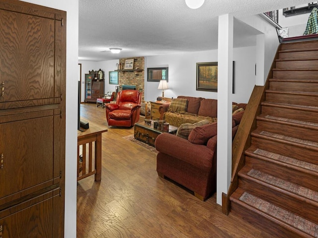 24810 96th St NW, Zimmerman, MN 55398 - living room with wood finished floors, stairway, a textured ceiling, and a fireplace