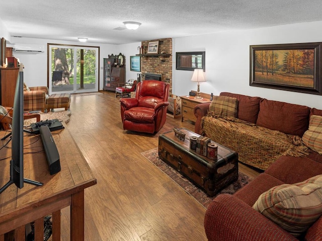 24810 96th St NW, Zimmerman, MN 55398 - living area featuring wood finished floors, a wall mounted AC, a textured ceiling, and a brick fireplace