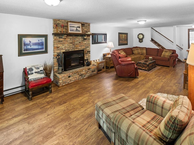 24810 96th St NW, Zimmerman, MN 55398 - living room featuring baseboard heating, a textured ceiling, wood finished floors, stairway, and a fireplace
