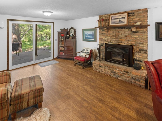 24810 96th St NW, Zimmerman, MN 55398 - living room with wood finished floors, a textured ceiling, and a brick fireplace