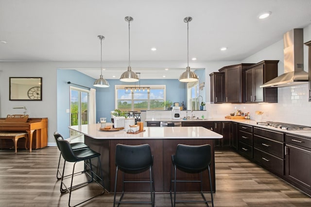 19281 Blue Stem Ct, Maple Grove, MN 55311 - kitchen featuring wall chimney exhaust hood, appliances with stainless steel finishes, light countertops, dark wood-style flooring, and backsplash