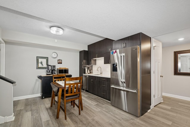 19281 Blue Stem Ct, Maple Grove, MN 55311 - kitchen featuring appliances with stainless steel finishes, a sink, light countertops, baseboards, and light wood finished floors