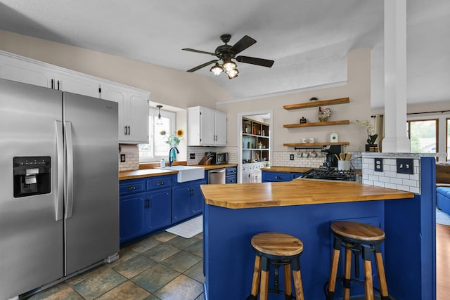 2708 94th Ave N, Brooklyn Park, MN 55444 - kitchen with appliances with stainless steel finishes, butcher block counters, blue cabinetry, a sink, and tasteful backsplash