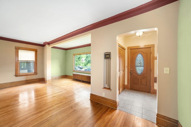 1027 Van Slyke Ave, Saint Paul, MN 55103 - foyer featuring radiator heating unit, hardwood / wood-style floors, arched walkways, ornamental molding, and baseboards