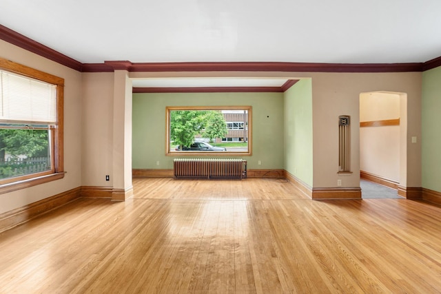 1027 Van Slyke Ave, Saint Paul, MN 55103 - spare room with radiator, crown molding, light wood-style flooring, and baseboards