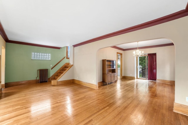 1027 Van Slyke Ave, Saint Paul, MN 55103 - unfurnished living room featuring arched walkways, a chandelier, light wood finished floors, ornamental molding, and stairs
