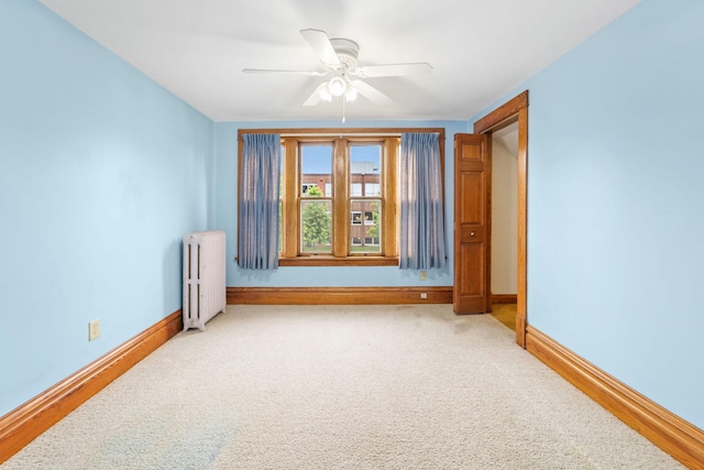 1027 Van Slyke Ave, Saint Paul, MN 55103 - unfurnished room featuring radiator heating unit, a ceiling fan, baseboards, and light colored carpet