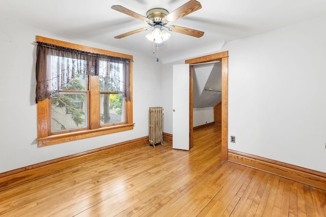 1027 Van Slyke Ave, Saint Paul, MN 55103 - spare room featuring radiator, baseboards, light wood-style floors, and ceiling fan