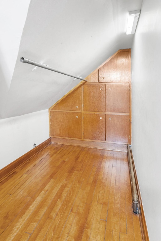 1027 Van Slyke Ave, Saint Paul, MN 55103 - additional living space with vaulted ceiling, light wood-style floors, and baseboards