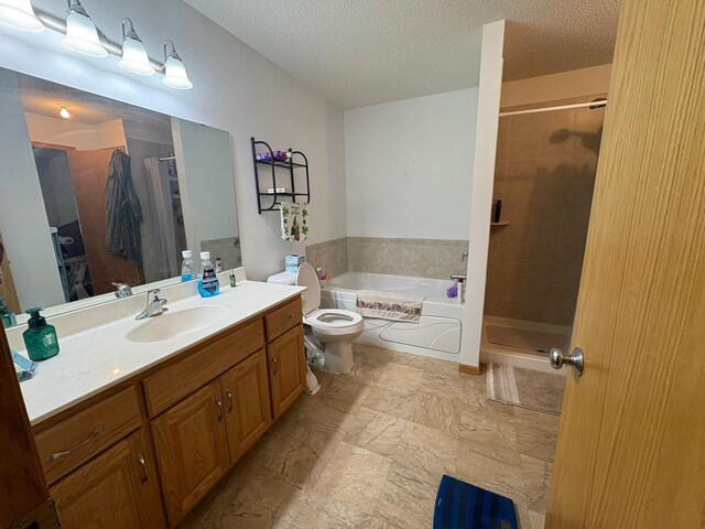 5460 100th Ln N, Brooklyn Park, MN 55443 - bathroom with vanity, a garden tub, a shower stall, toilet, and a textured ceiling