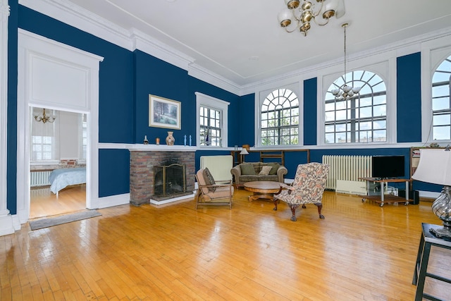 2306 5th St, Superior, WI 54880 - sitting room featuring a chandelier, a brick fireplace, healthy amount of natural light, hardwood / wood-style floors, and crown molding