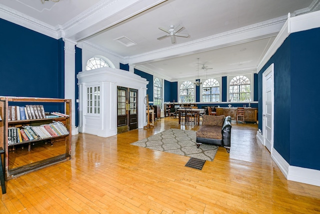 2306 5th St, Superior, WI 54880 - living room featuring crown molding, hardwood / wood-style flooring, a ceiling fan, and decorative columns