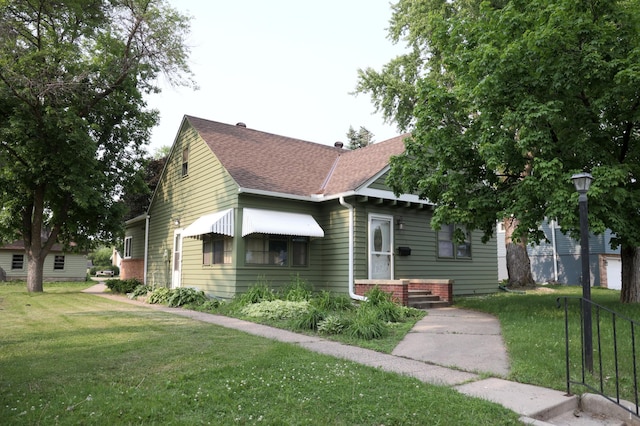 105 2nd St NE, New Prague, MN 56071 - bungalow-style house featuring roof with shingles and a front lawn